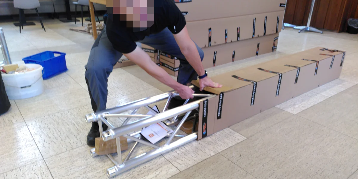 Eine Traverse wird aus ihrem Verpackungskarton gezogen