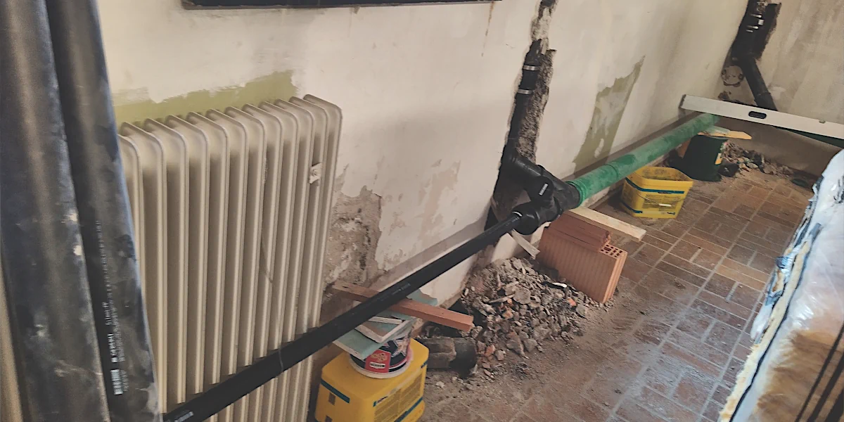 Abflussrohre, die auf Ziegeln und Eimern abgestützt werden