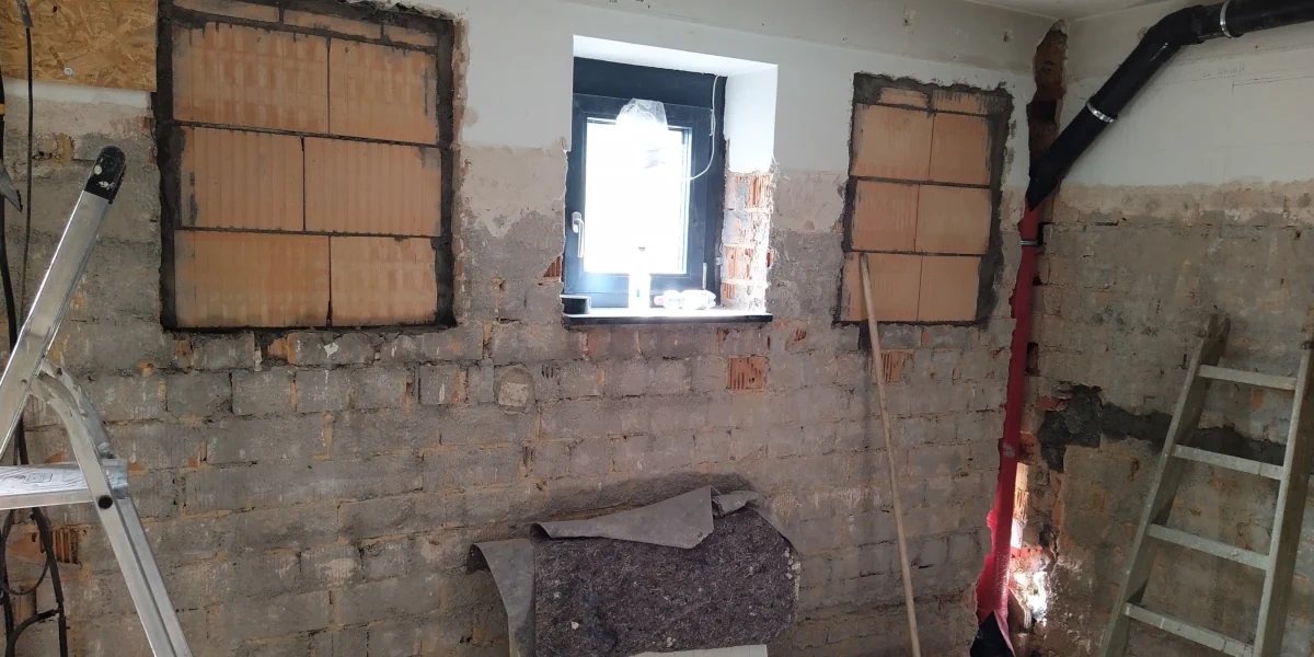 zugemauerte Fenster und verlegt Abwasserleitung