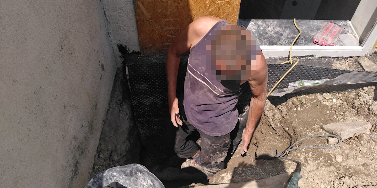 Mann steht in einem Erdloch