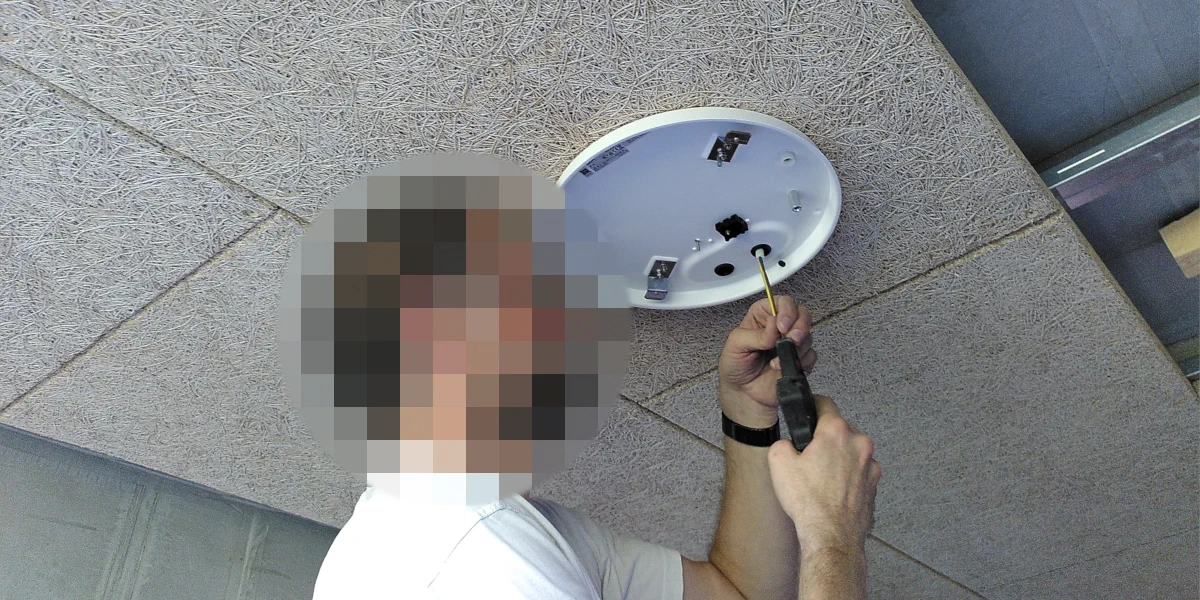 Mann der die Halter für die Deckenkonstrukion montiert