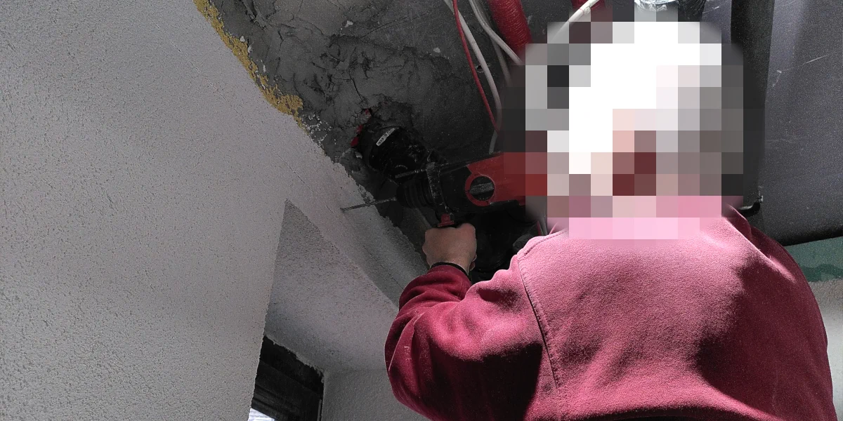 Mit einer Schlagbohrmaschine werden Löcher in eine Wand gebohrt