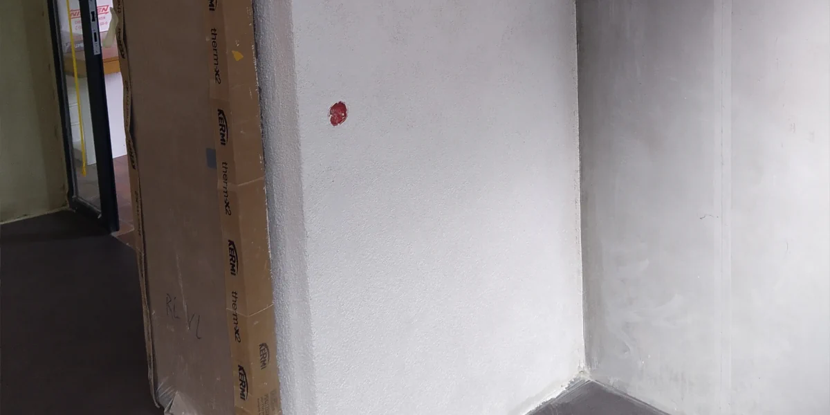 Mit einer Schlagbohrmaschine werden Löcher in eine Wand gebohrt