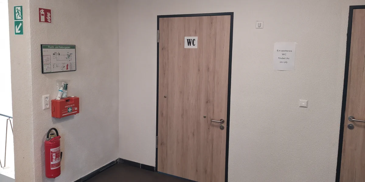 Person auf einem Gerüst verspachtelt die hohes Fenster